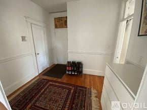 Boston apartment for rent - A room with a rug and a bottle of wine on the floor.