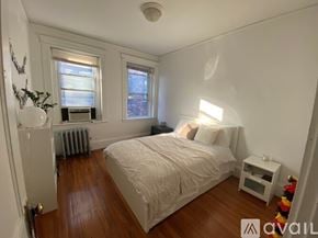 Boston apartment for rent - A bedroom with a bed, nightstand, and window.