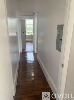 Boston apartment for rent - A long hallway with wood floors and white walls.