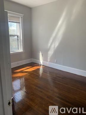 Boston apartment for rent - A room with wooden floors and a window letting in sunlight.
