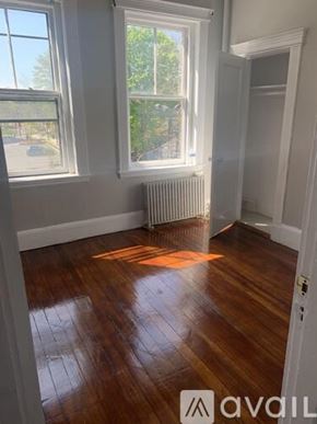 Boston apartment for rent - A room with wooden floors and two windows.