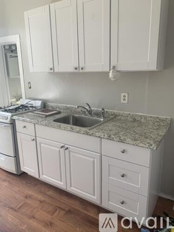Boston apartment for rent - A kitchen with white cabinets and a granite countertop.