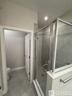 Naples condo for rent - A bathroom with a walk-in shower and a toilet.