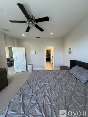 Naples condo for rent - A bedroom with a large bed and a ceiling fan.