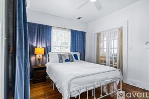 St. Petersburg apartment for rent - A bedroom with a white bed and blue curtains.