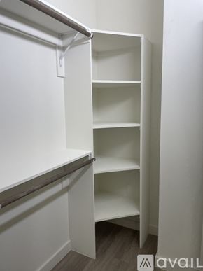 Denver apartment for rent - A white shelving unit with four shelves is mounted on a white wall.