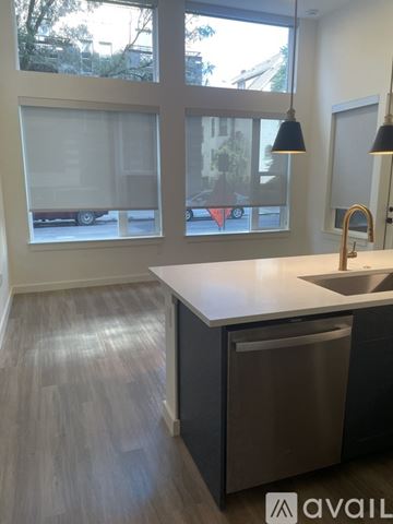 Denver apartment for rent - A kitchen with a white counter top and a grey trash can.