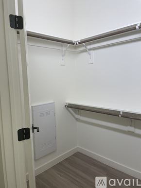Denver apartment for rent - A white door with a black handle is open to a small room with a white cabinet and a white shelf.