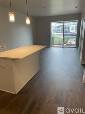 Denver apartment for rent - A large open space with a white counter and wooden flooring.