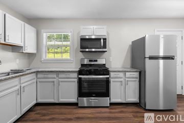 Atlanta house for rent - A kitchen with white cabinets and stainless steel appliances.