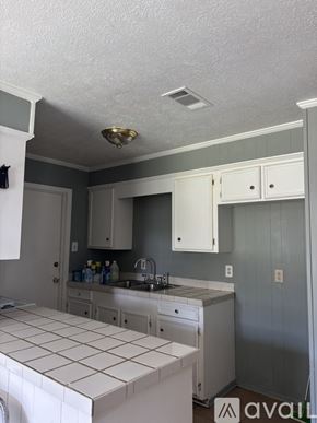 Jackson house for rent - A bathroom with a white tiled counter top and white cabinets.