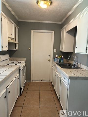 Jackson house for rent - A kitchen with white cabinets and a white door.