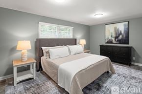 Asheville house for rent - A bedroom with a large bed, a nightstand with a lamp, and a painting on the wall.