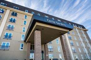 Winnipeg apartment for rent - The front of a building with the words Castle Gardens on it.