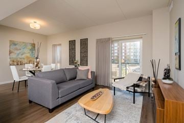 Winnipeg apartment for rent - A grey couch sits in a living room with a wooden coffee table in front of it.