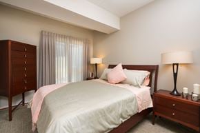 Winnipeg apartment for rent - A bedroom with a bed, nightstand, and lamp.