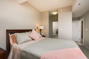 Winnipeg apartment for rent - A bedroom with a bed, nightstand, and lamp.