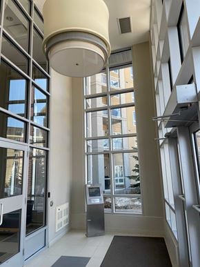 Winnipeg apartment for rent - A white ceiling light hangs over a glass door entrance.