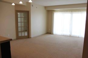 Winnipeg apartment for rent - A room with a carpeted floor and a door with a glass panel.