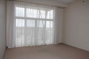Winnipeg apartment for rent - A room with a large window covered by sheer curtains.