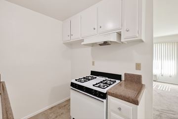 Fullerton apartment for rent - A white kitchen with a stove top oven and cabinets.