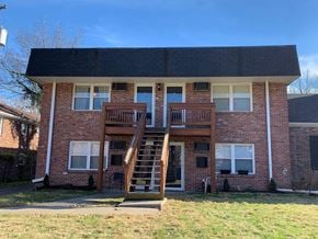 Lexington apartment for rent - A brick house with a wooden deck and stairs leading to the front door.