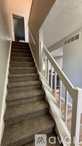 Indianapolis house for rent - A staircase with a carpeted runner and white balusters.
