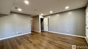 Indianapolis house for rent - A spacious room with wooden flooring and a doorway leading to another room.