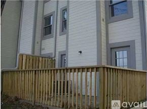 Indianapolis house for rent - A wooden fence in front of a building with windows.