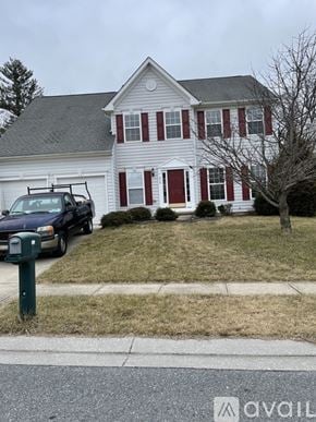 Owings Mills house for rent - A white house with red shutters and a black car parked in front.