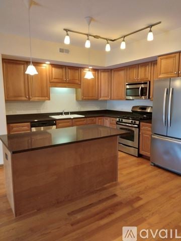 Chicago apartment for rent - A kitchen with wooden cabinets and a black countertop.