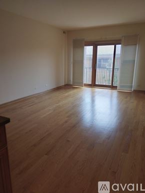 Chicago apartment for rent - A room with wooden flooring and a balcony with glass doors.