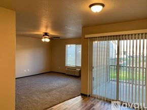 Box Elder apartment for rent - A room with a ceiling fan and sliding glass doors.