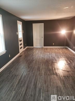 Albany house for rent - A room with dark wood flooring and a white door.
