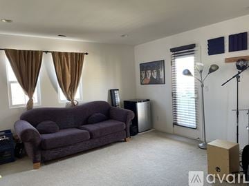San Ramon house for rent - A living room with a purple couch and a painting on the wall.