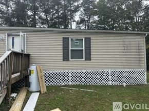 Leonardtown house for rent - A mobile home with a white fence and a small porch.