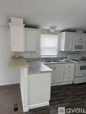 Leonardtown house for rent - A kitchen with white cabinets and a marble countertop.