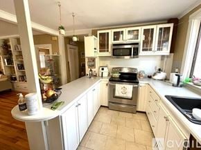 Chelmsford condo for rent - A kitchen with a white countertop and a stove top oven.