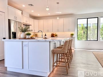 Phoenix house for rent - A modern kitchen with white cabinets and a wooden floor.