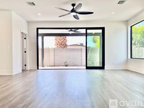 Phoenix house for rent - A spacious room with a ceiling fan and sliding glass doors leading to a backyard.