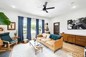 San Antonio house for rent - A living room with a blue chair, a beige sofa, and a wooden coffee table.