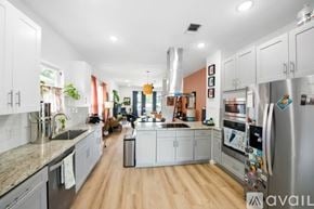 San Antonio house for rent - A kitchen with white cabinets and a wooden floor.