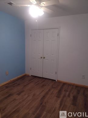 Yukon house for rent - A room with a white door and wooden flooring.