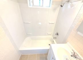 Warren house for rent - A white bathroom with a tub, sink, and shower.