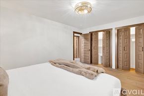 Homewood condo for rent - A bedroom with a large bed and a chandelier.