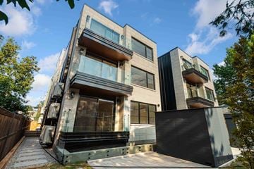 Ottawa apartment for rent - A modern two-story house with a black fence and glass balconies.
