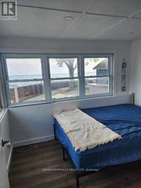 Chatham-Kent (Blenheim) house for rent - A bedroom with a bed and a window overlooking the beach.
