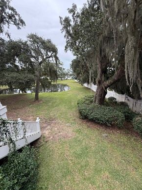 Pawleys Island house for rent - A white fence runs along the edge of a grassy area.