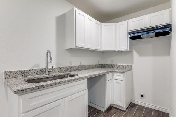 San Antonio apartment for rent - A kitchen with white cabinets and a granite countertop.