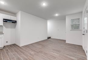 San Antonio apartment for rent - A spacious room with wooden flooring and white walls.